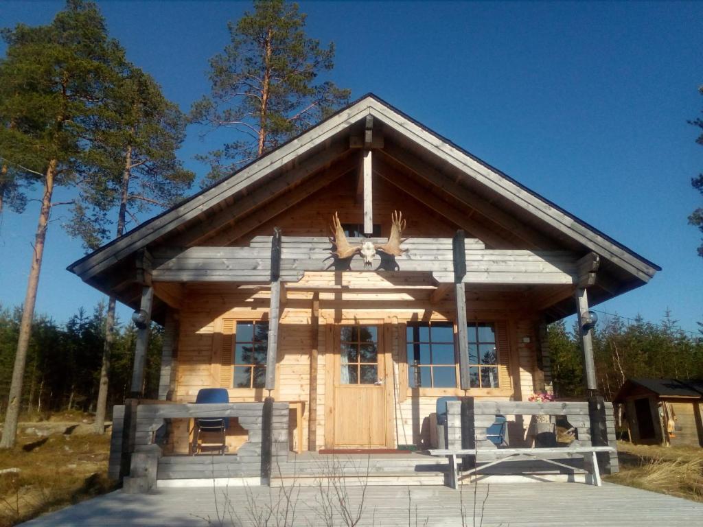Cabaña de madera con una gran puerta delantera en Tarinatupa Simojärvi, en Impiö