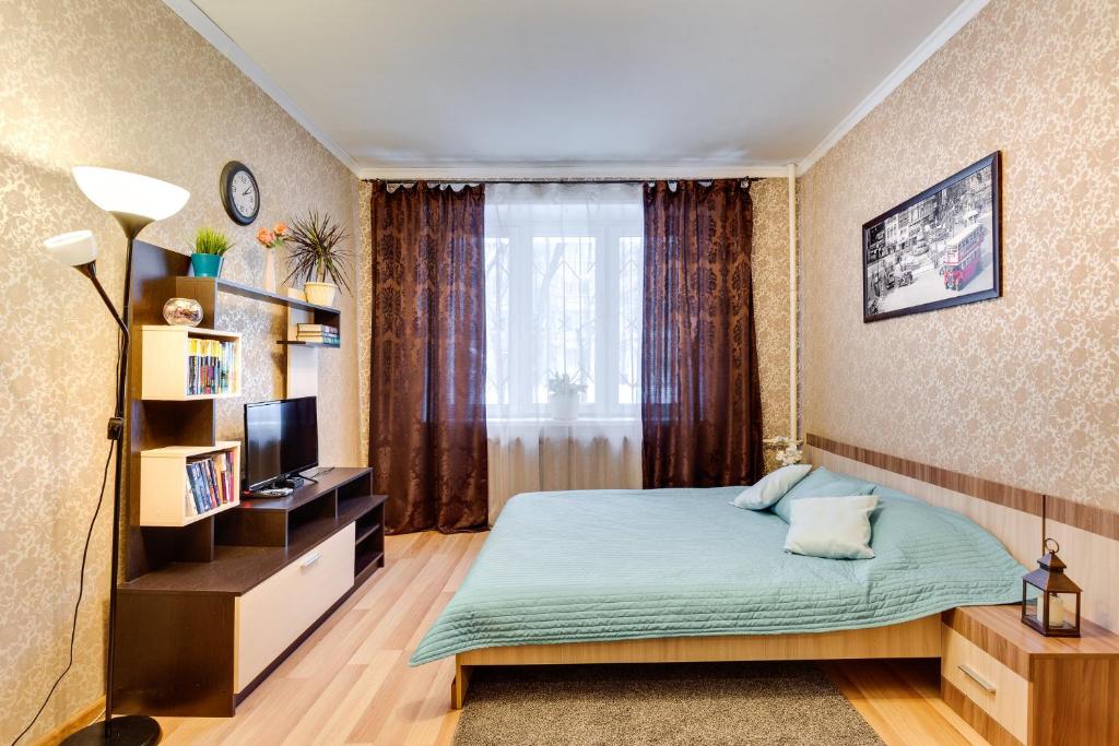 モスクワにあるApartaments on Vernadskiy prospektの小さなベッドルーム(ベッド1台、テレビ付)