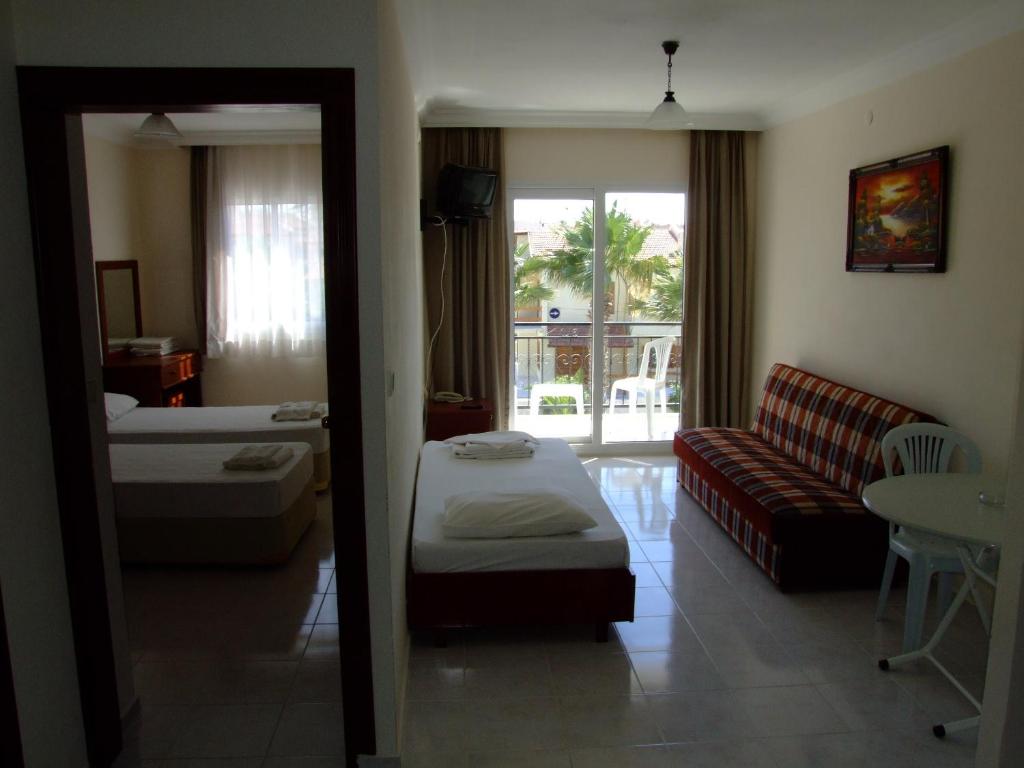 a living room with a bed and a couch at Albayrak Hotel in Cesme