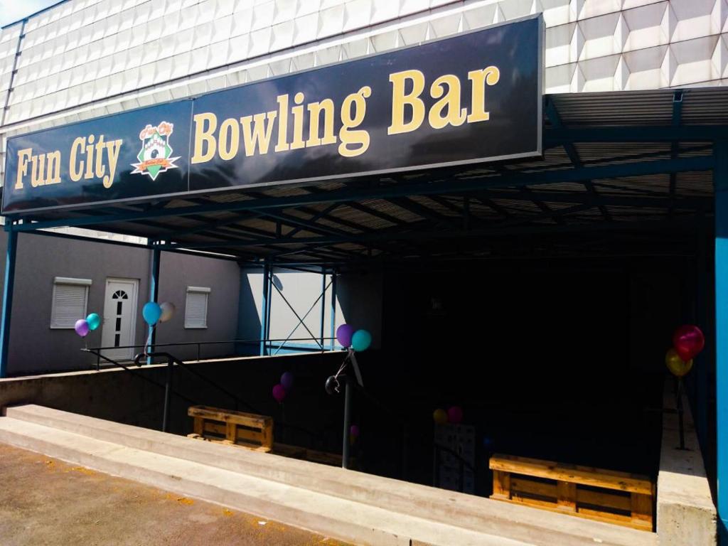 a bowling bar with two benches and a sign at City Apartman in Nyíregyháza