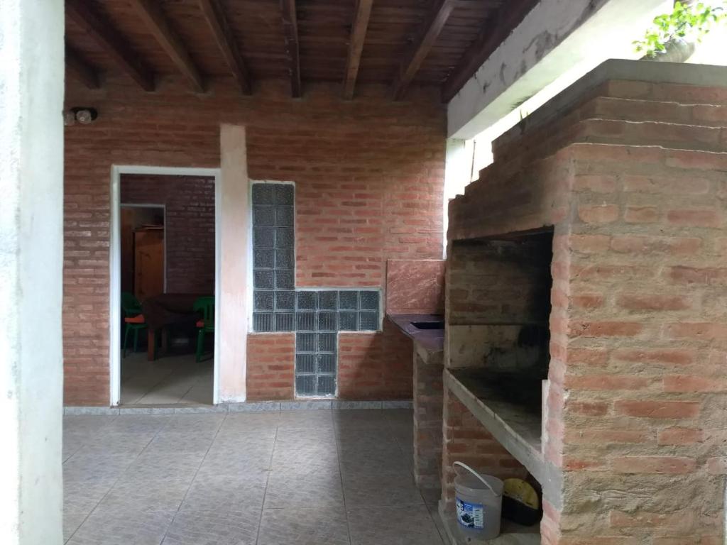 una cocina al aire libre con una pared de ladrillo y una puerta abierta en La Tribu en Paso de la Patria