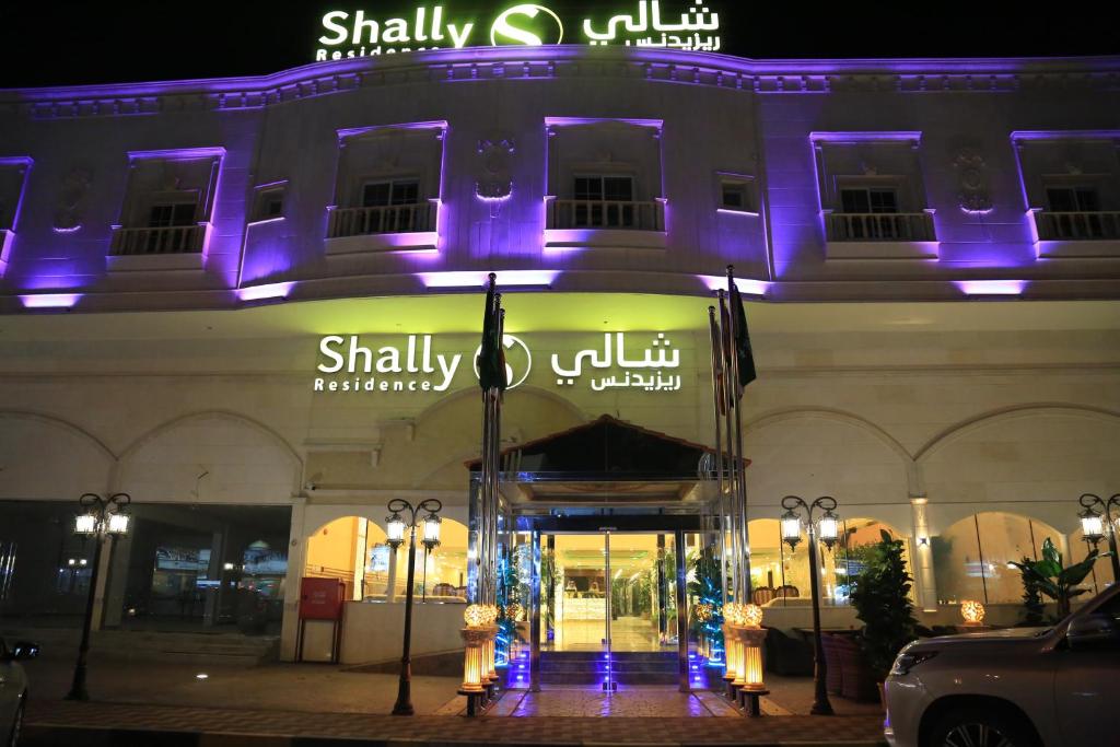 un edificio con luces púrpuras en la parte delantera en SHALLY RESIDENCE 3 en Al Khobar