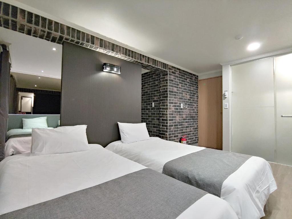 Postel nebo postele na pokoji v ubytování Hotel Tong Yeondong Jeju