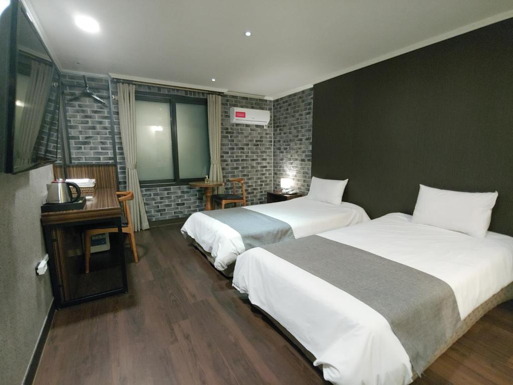 Postel nebo postele na pokoji v ubytování Hotel Tong Yeondong Jeju