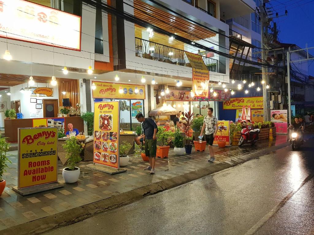 a group of people standing in front of a store at Benny's City Hotel in Sihanoukville