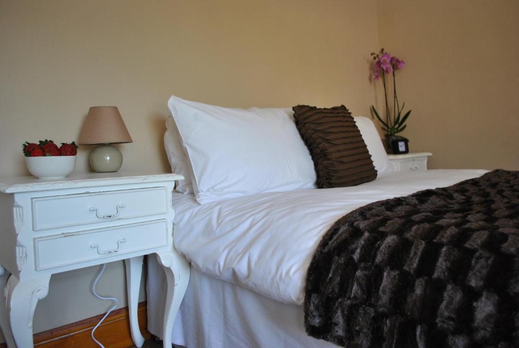 a bedroom with a white bed with a white nightstand and a white bedskirts at Amber Guesthouse in Derby