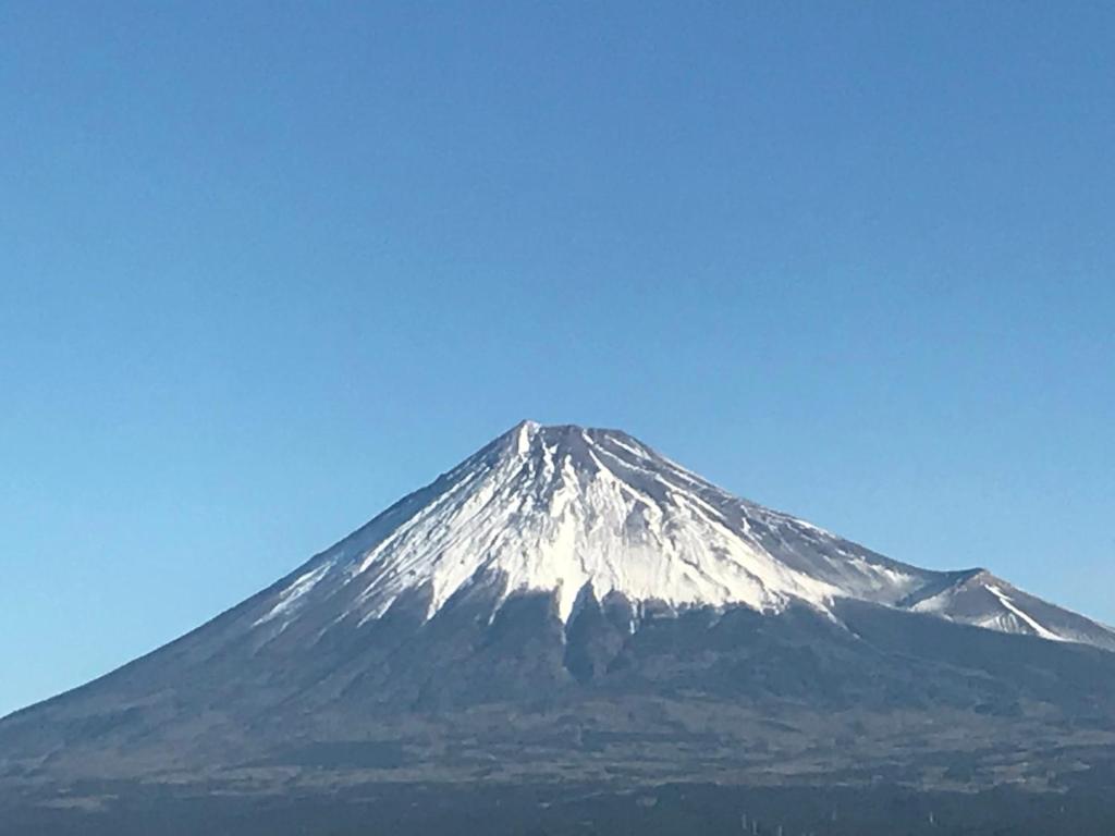 una montaña cubierta de nieve con un cielo azul en el fondo en Bougakuan, en Fuji