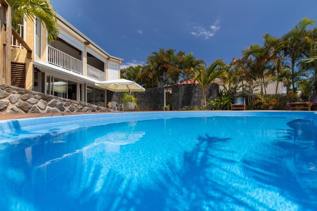une grande piscine bleue en face d'une maison dans l'établissement Villa Tangor, à Petite Île