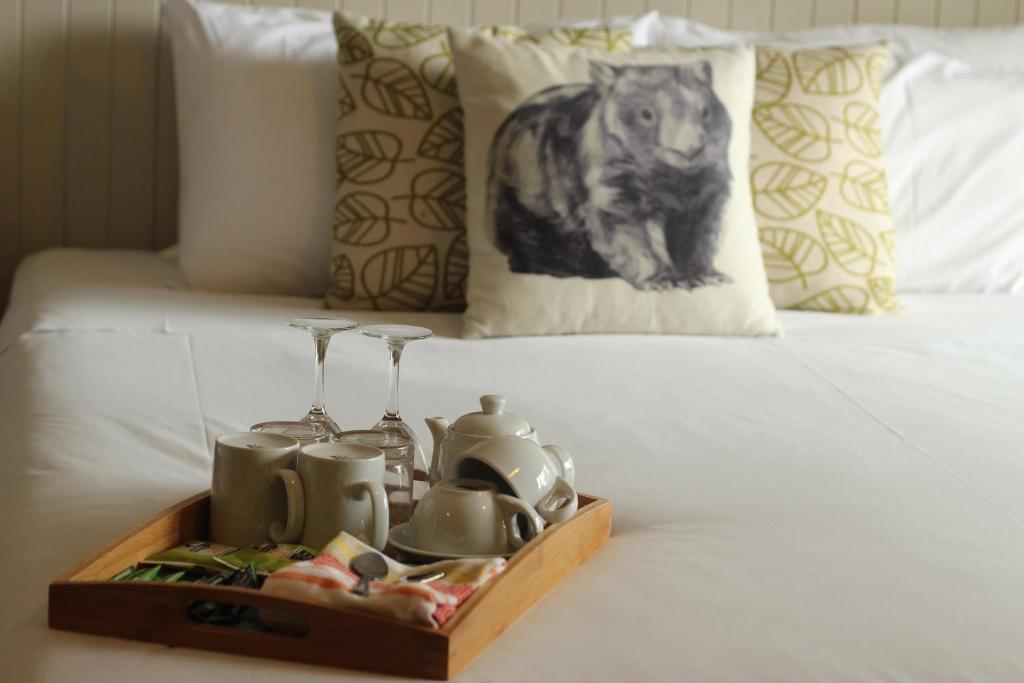 um tabuleiro de teaiments sentado em cima de uma cama em Jindy Inn em Jindabyne