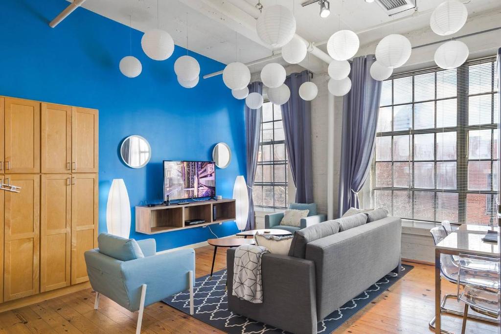 a living room with blue walls and a couch and chairs at Trifecta 2BR Free Parking Modern Superhost in Durham