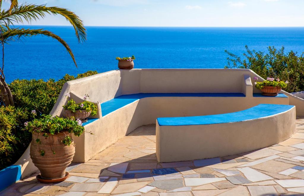 un banc sur une terrasse avec l'océan en arrière-plan dans l'établissement Mirtopolis, à Myrtos