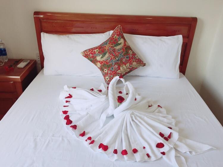 a white bed with a heart made out of roses at CANH DUONG MOTEL in Lang Co