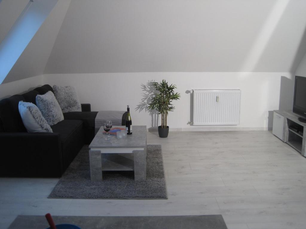 a living room with a black couch and a table at Töfte Bude in Mülheim an der Ruhr