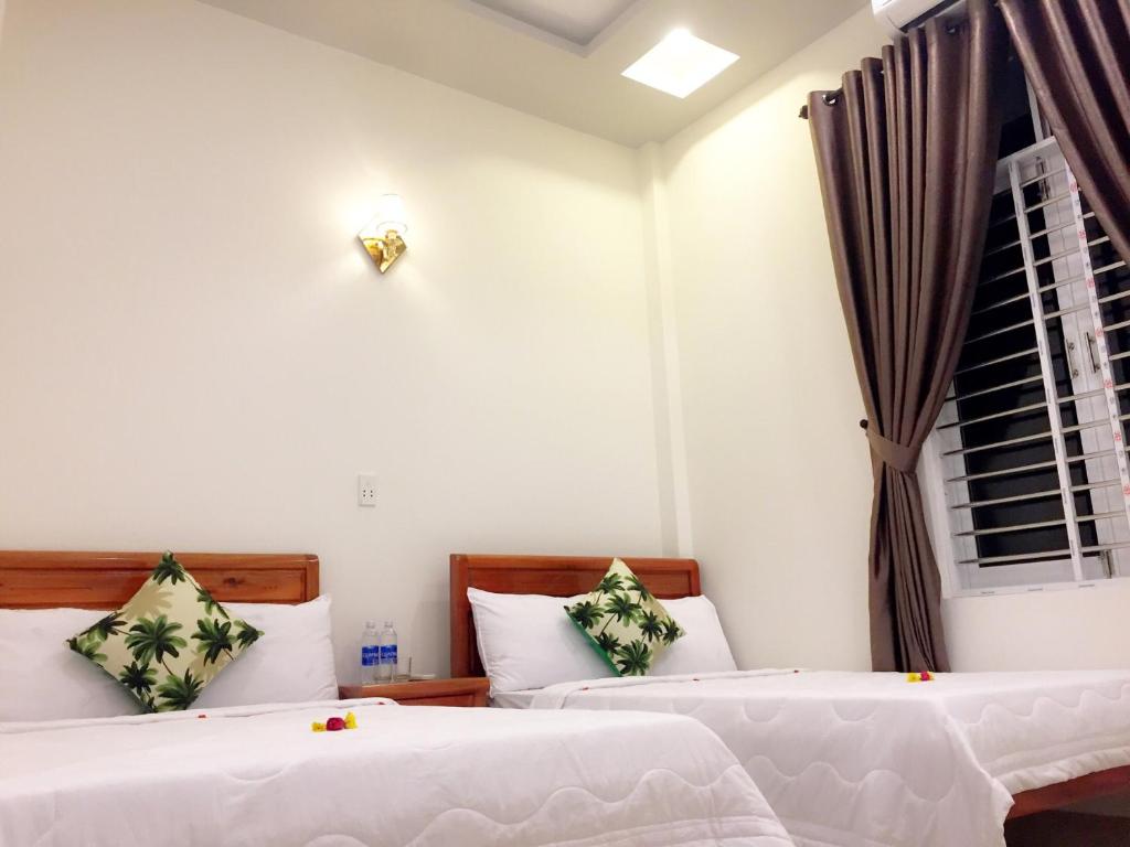 a bedroom with two beds and a window at CANH DUONG MOTEL in Lang Co
