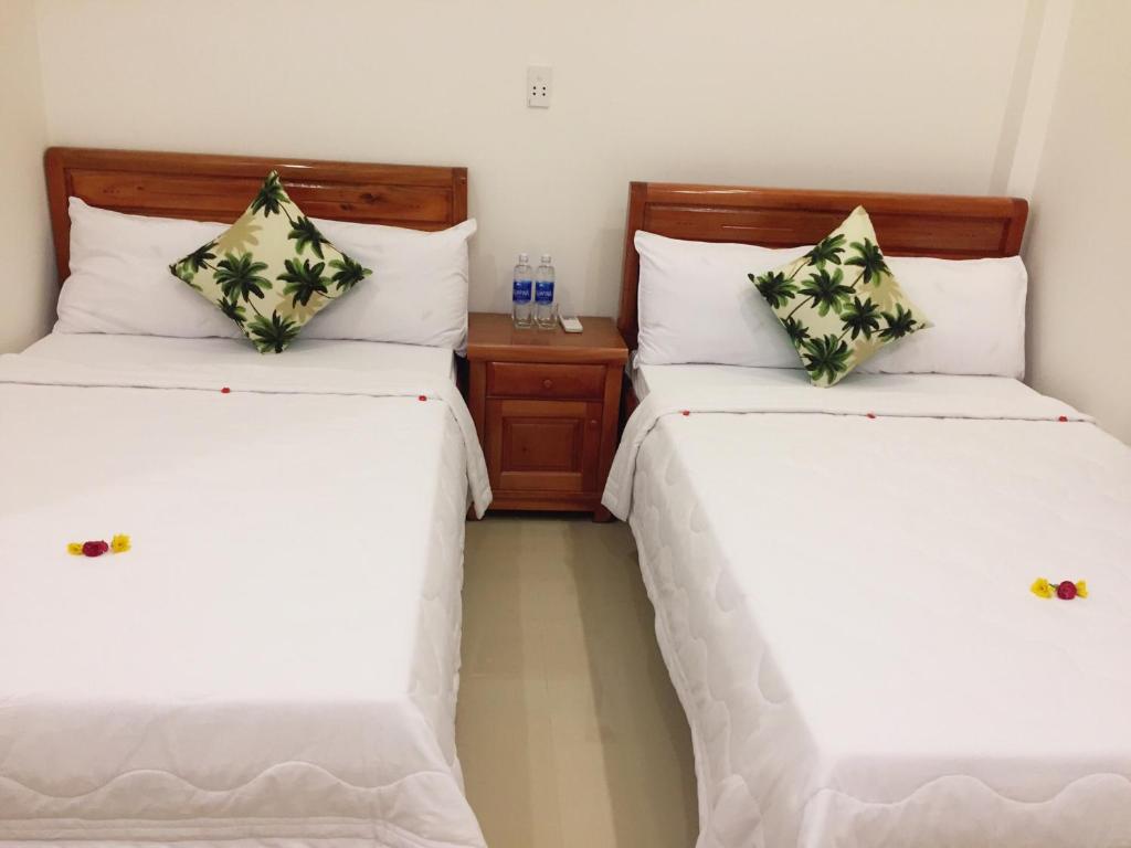 two beds sitting next to each other in a room at CANH DUONG MOTEL in Lang Co