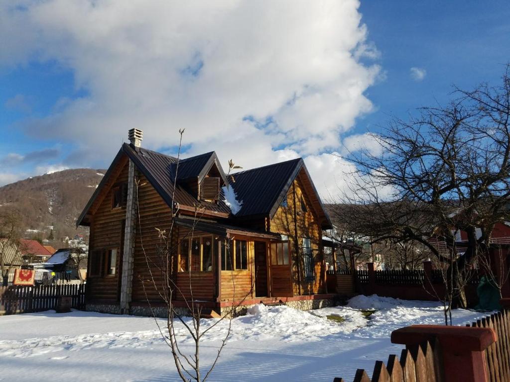 a wooden house with snow on the ground at Holiday Home Angie in Kolašin