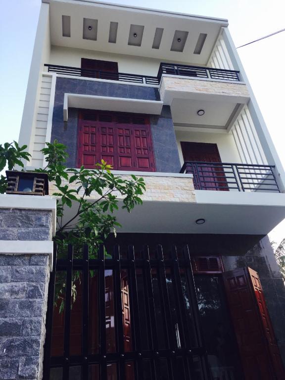 a house with red doors and a black gate at CANH DUONG MOTEL in Lang Co