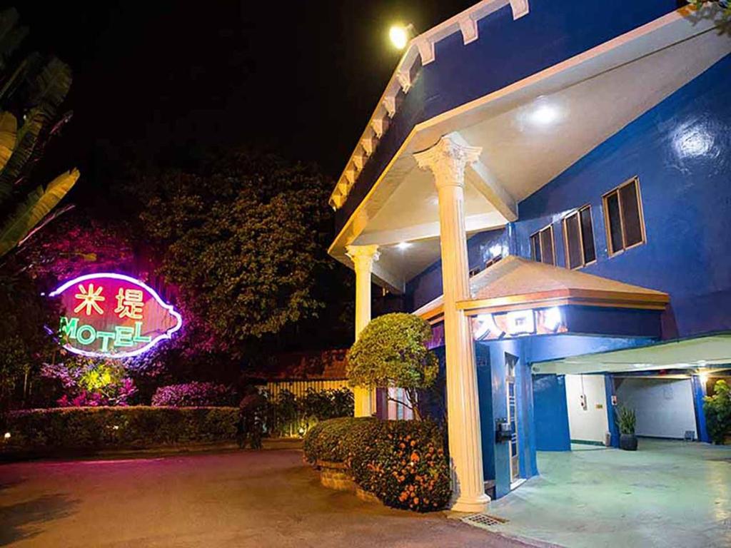un hôtel avec un néon devant lui dans l'établissement Midi Motel Pingtung Branch, à Pingtung
