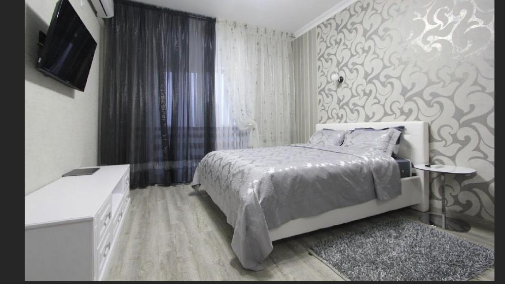 a bedroom with a bed and a television in it at Apartment deluxe in Chişinău