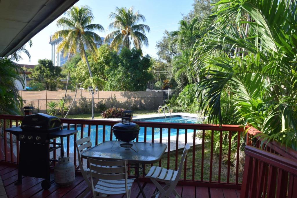 einen Balkon mit einem Tisch, Stühlen und einem Pool in der Unterkunft Home in the Heart of Miami in Miami