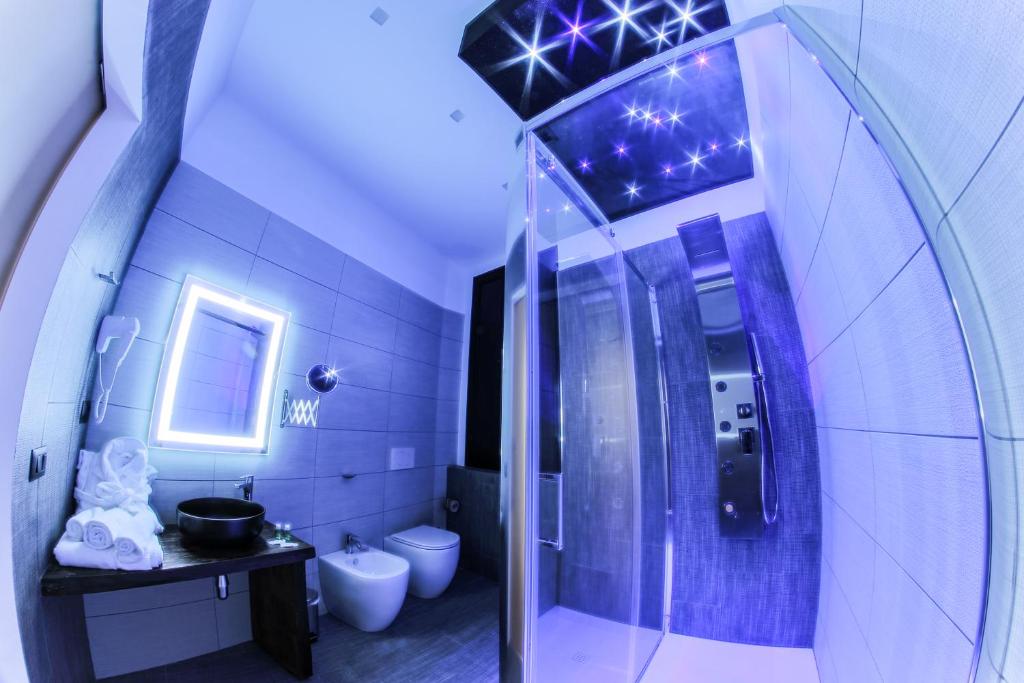 a blue bathroom with a shower and a toilet at RESIDENZE CASSOLI B&B Luxury Spa in Lamezia Terme