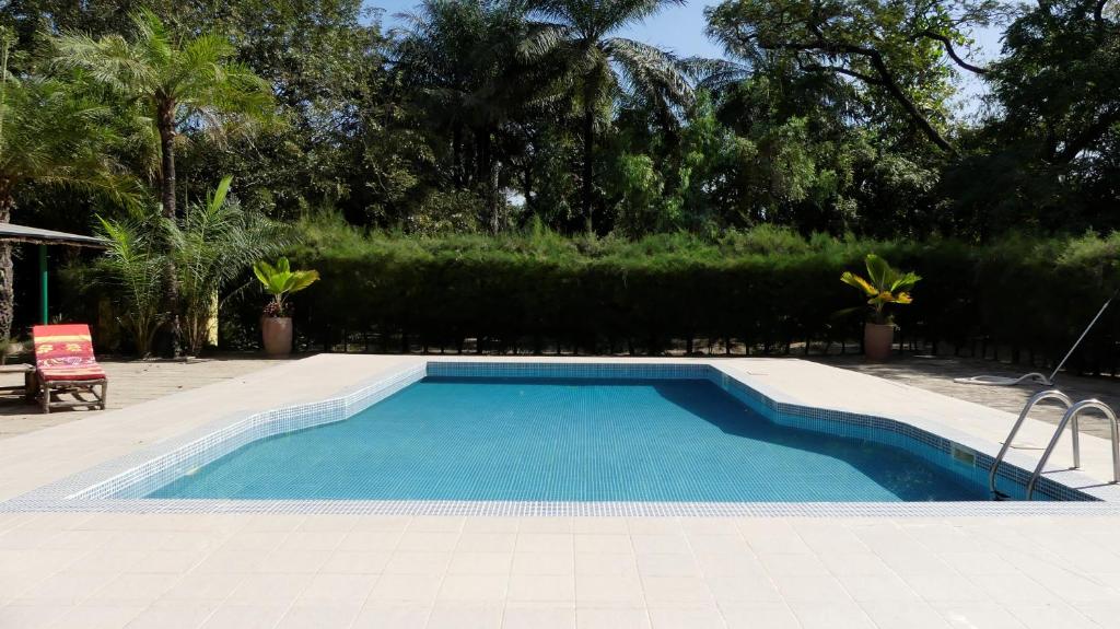 a swimming pool with blue water in a yard at Tendinkoto Lodge in Sanyang