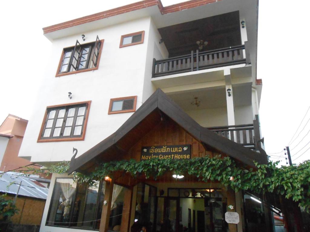 a white building with a balcony on top of it at Maylay Guesthouse in Vang Vieng