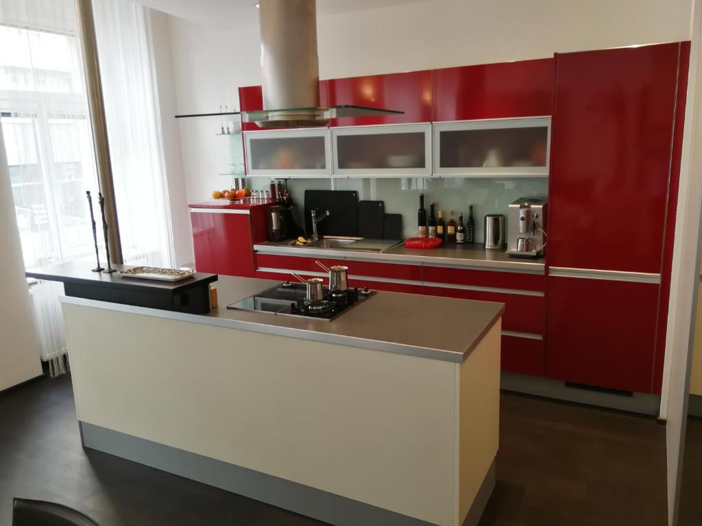a kitchen with red cabinets and a counter top at Grand Vienna City Center Apartment in Vienna