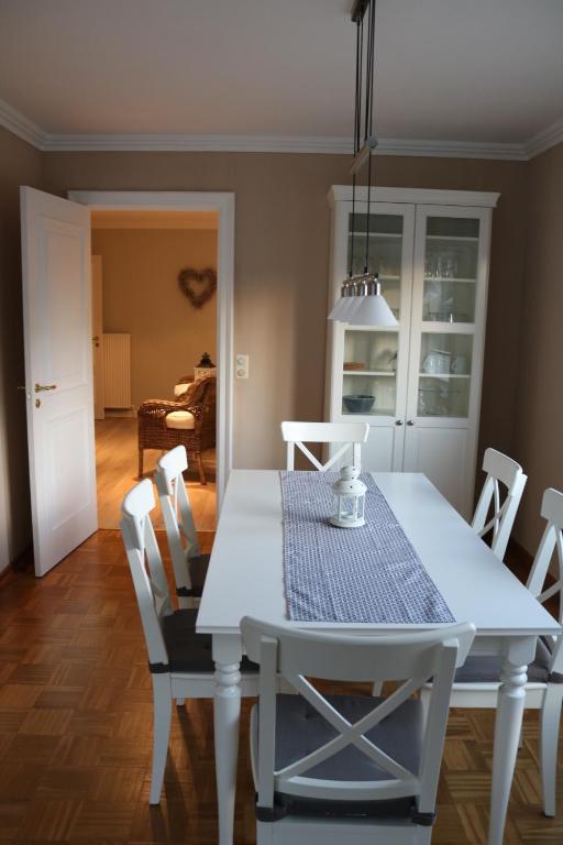 ein Esszimmer mit einem weißen Tisch und Stühlen in der Unterkunft Nordseeperle Husum in Husum