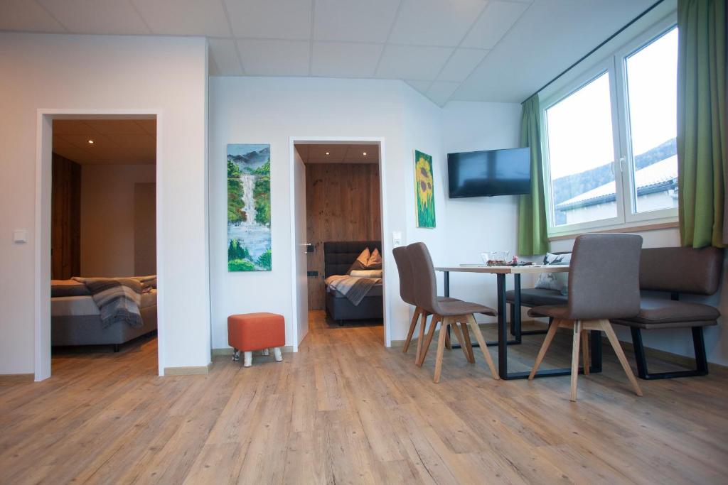 een woonkamer met een tafel en stoelen en een slaapkamer bij Chalet West in Sillian