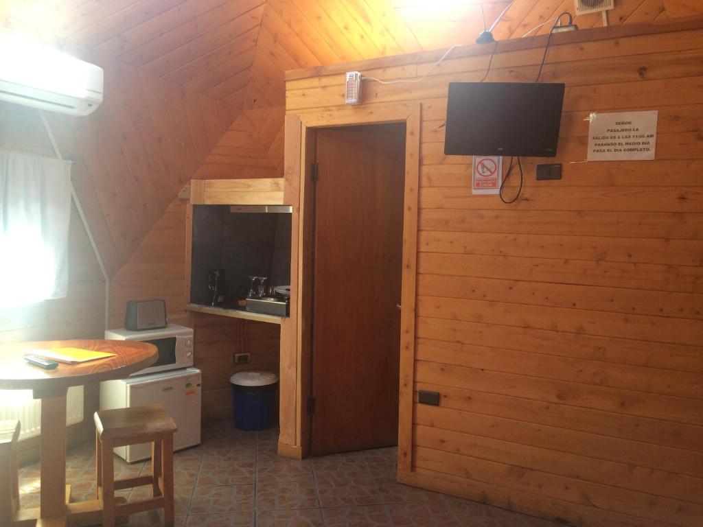 a room with a door and a television on a wall at Karü Domos del Fuy in Neltume