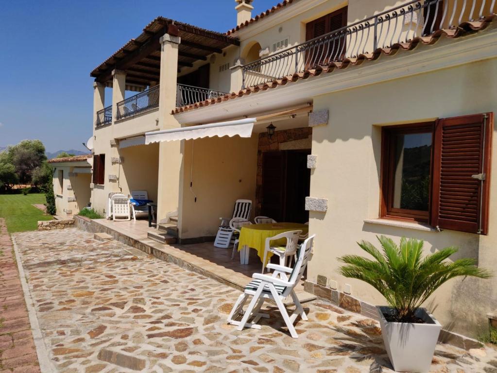 una casa con sedie e un tavolo su un patio di Villetta Oleandro - vista montagna a Tanaunella