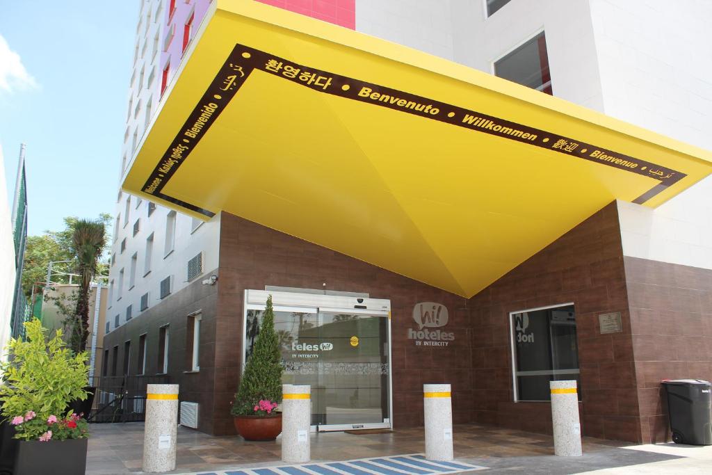 un edificio con un toldo amarillo delante de él en Hotel Hi! Queretaro en Querétaro
