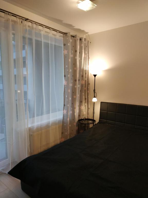 a bedroom with a bed and a large window at Košice Smart Apartmán in Košice