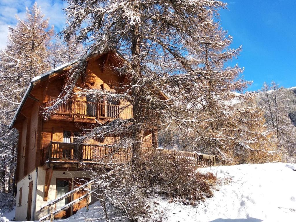 una baita di tronchi nel bosco nella neve di ChaletauxOrres au pied des pistes et skis aux pieds a Les Orres