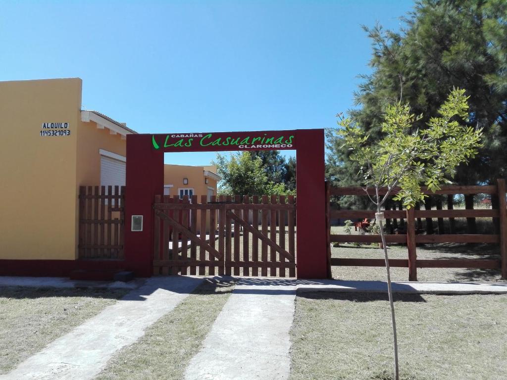 una puerta de madera con una señal frente a un edificio en Las Casuarinas Claromeco en Balneario Claromecó