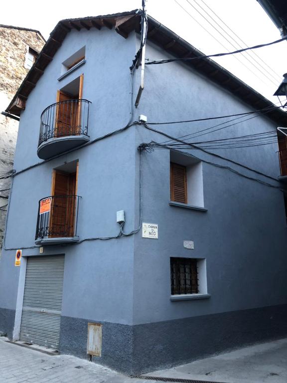 un edificio azul con 2 balcones en una calle en Casa Serraller, en Esterri d'Àneu