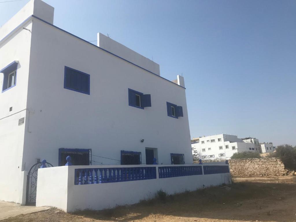 ein weißes Gebäude mit Seitenfenstern in der Unterkunft Chez Amel Guoumi in Oualidia
