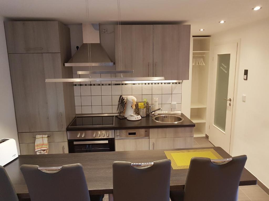 a kitchen with a table with chairs and a sink at Fewo Hoheneggelsen in Söhlde