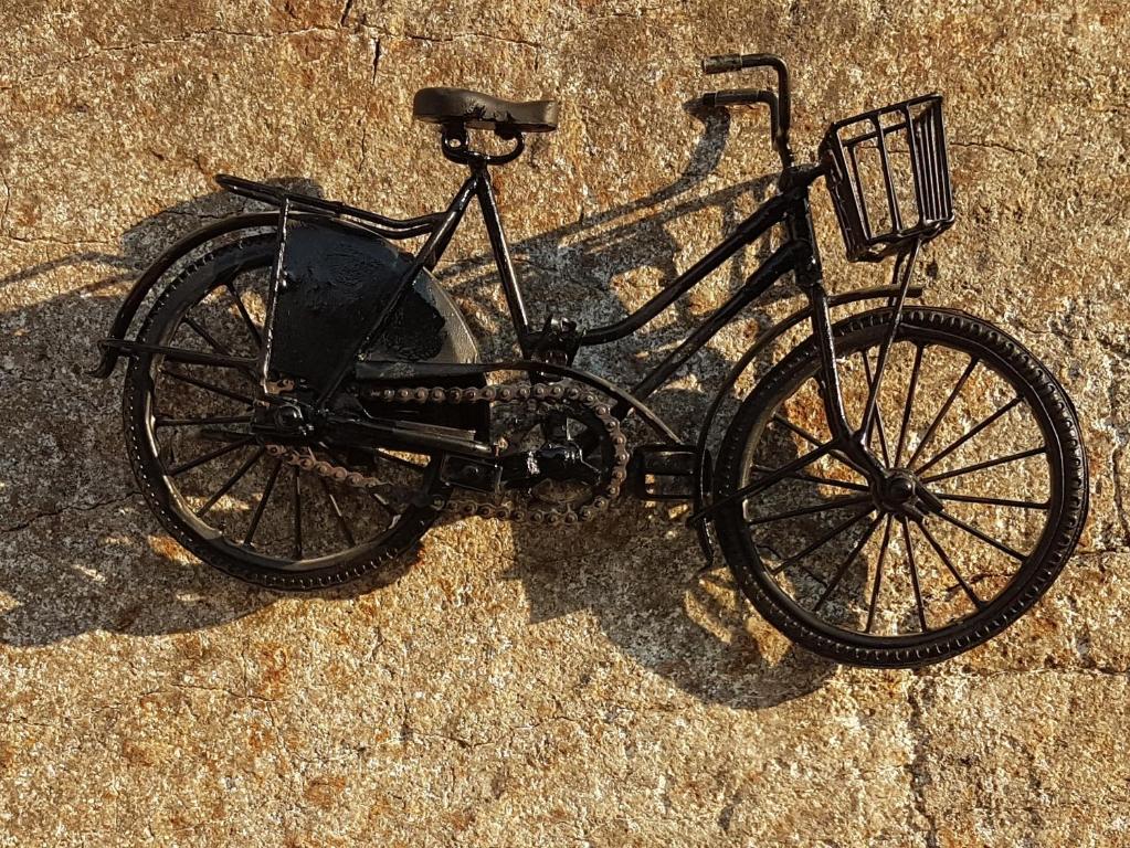 a black bike with a basket sitting on the ground at Bicycle House in Felgueiras