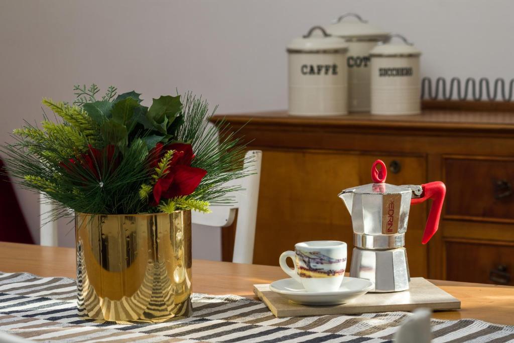 un vase avec une bougie et une tasse sur une table dans l'établissement Giù al Centro, à Naples