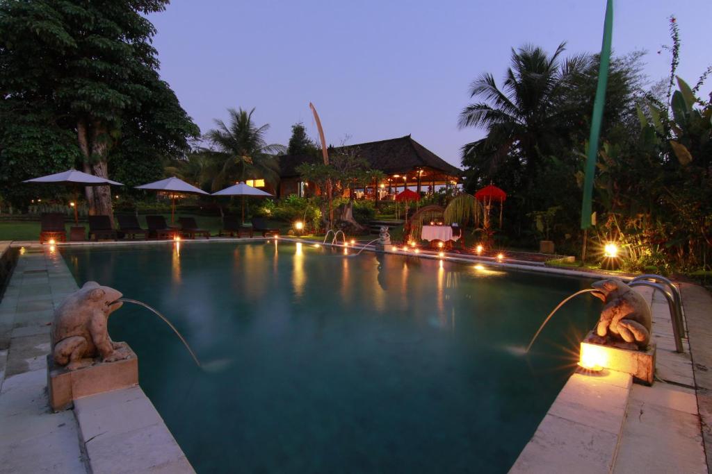 a swimming pool with lights in a resort at night at Subak Tabola Villa in Sidemen