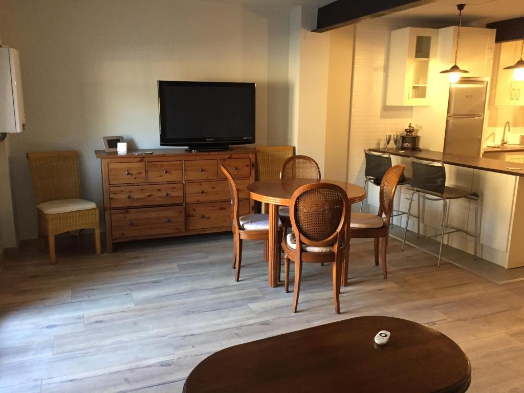 uma sala de estar com uma mesa e uma televisão e uma cozinha em Apartamento Vielha em Vielha