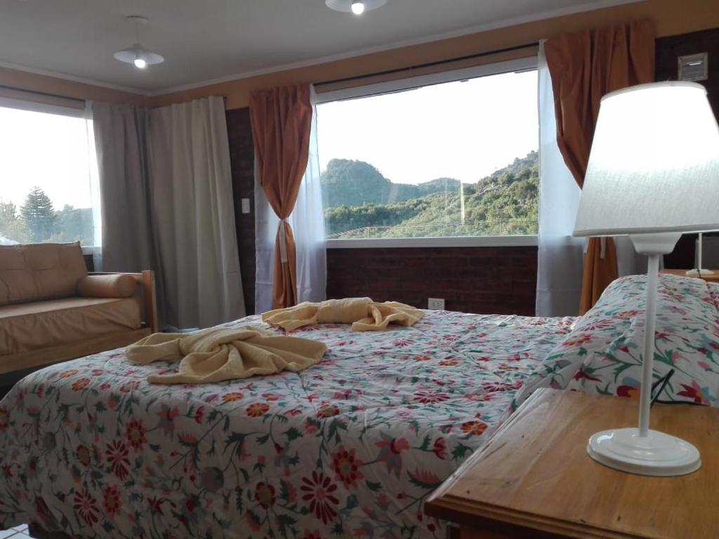 Un dormitorio con una cama con una manta. en Apart hotel Pehuenia en Villa Pehuenia