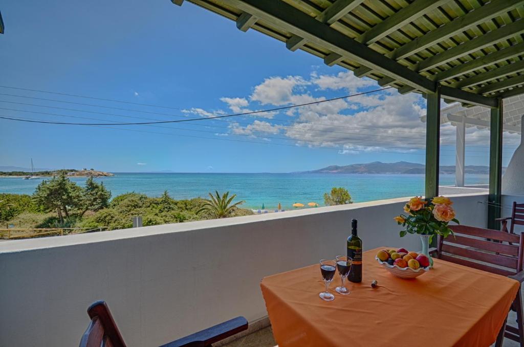 una mesa con una botella de vino y un bol de fruta en Margaritis Apartments, en Agia Anna de Naxos