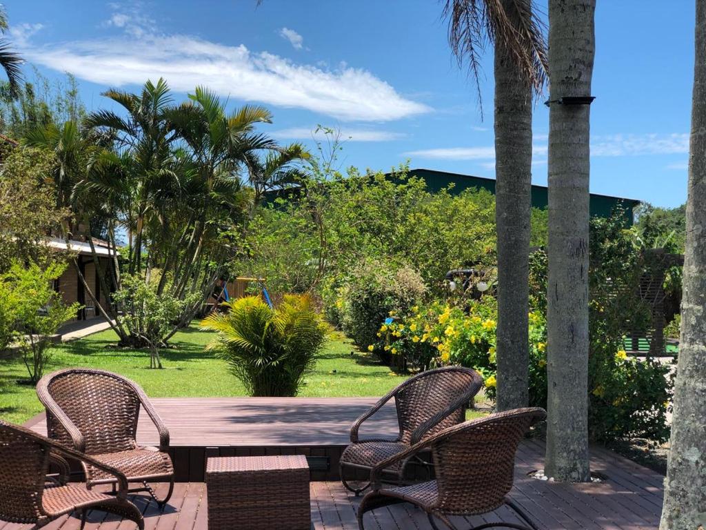 a wooden table with three chairs on a patio at Pousada A Cabana in Garopaba