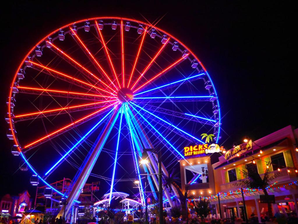 a ferris wheel at a carnival at night at Americana Inn a Travelodge by Wyndham in Pigeon Forge