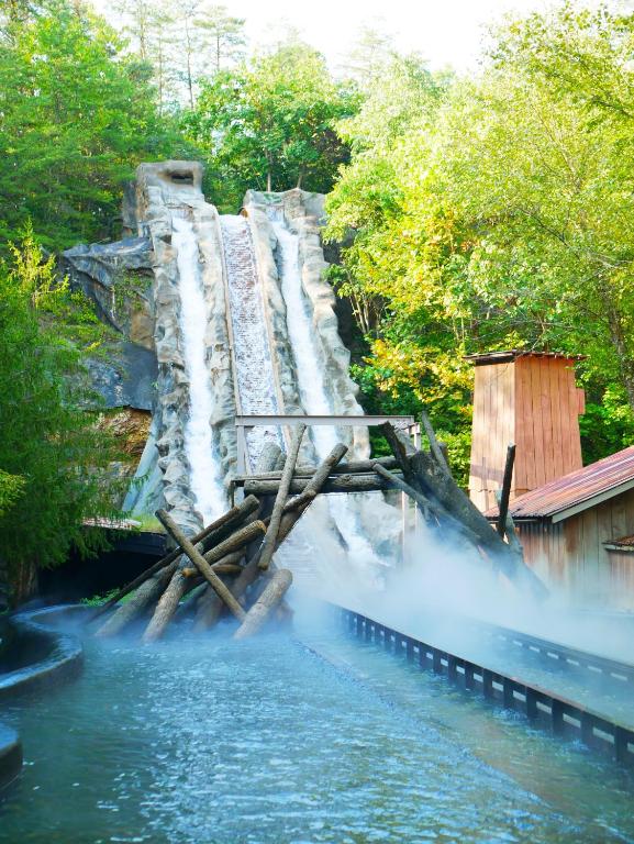 a waterfall in the middle of a river at Americana Inn a Travelodge by Wyndham in Pigeon Forge
