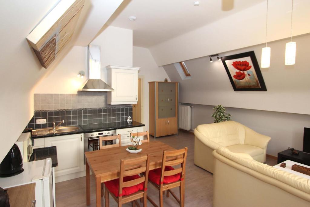 cocina y sala de estar con mesa de madera y sillas en Apartment Old Saxo, en Ypres