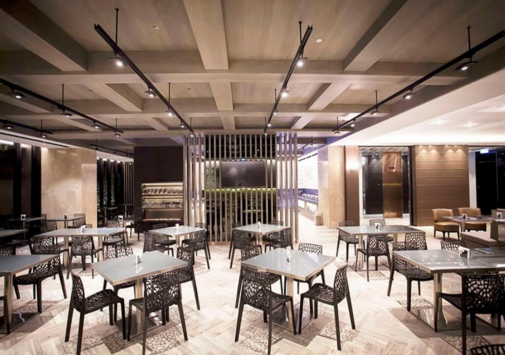 a restaurant with tables and chairs in a room at Royal Group Hotel Minghua Branch in Kaohsiung